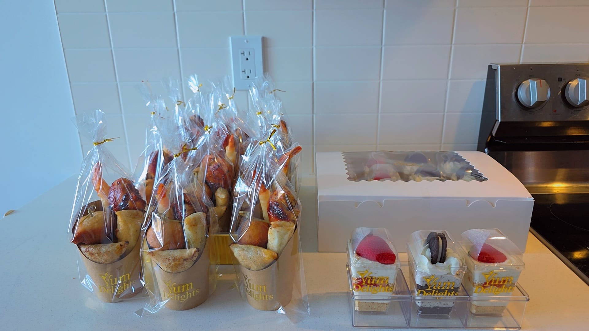 Individual Yum Delights grazing cups with puff puff, samosa, and glazed chicken